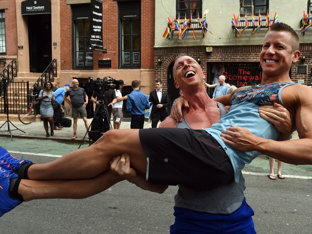 Justin Kattler e Tim Loecker, de Dallas, no Texas, celebram em frente ao bar Stonewall, conhecido pelo público gay e simpatizante, no bairro de West Village em Nova York, após o anúncio da liberação do casamento gay em todo o país (Foto: Timothy A. Clary/AFP)