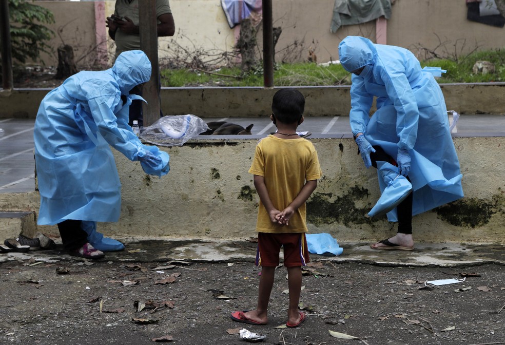 11 de julho - Profissionais da sa&uacute;de removem equipamentos de prote&ccedil;&atilde;o depois de examinar moradores em busca de sintomas de Covid-19, na favela Deonar, em Mumbai, na &Iacute;ndia. Em apenas tr&ecirc;s semanas, a &Iacute;ndia passou do sexto pa&iacute;s mais afetado pelo coronav&iacute;rus para o terceiro, segundo uma contagem pela Universidade Johns Hopkins &mdash; Foto: Rajanish Kakade/AP