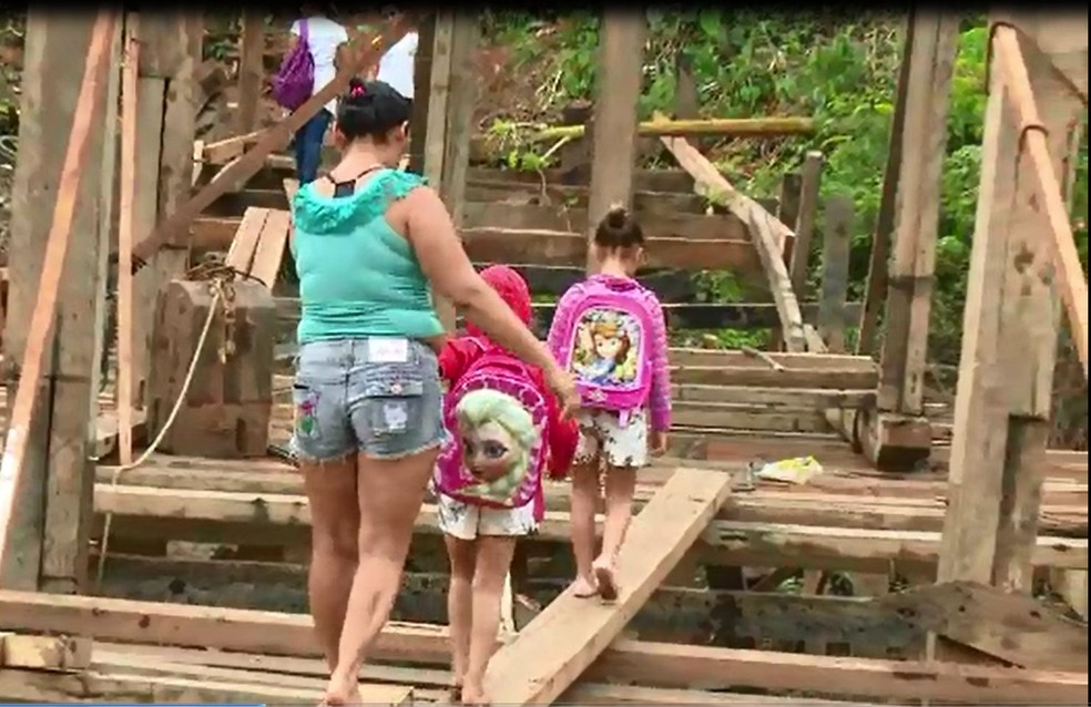 Mãe leva filhos para escola que fica no outro lado do igarapé  (Foto: Reprodução)