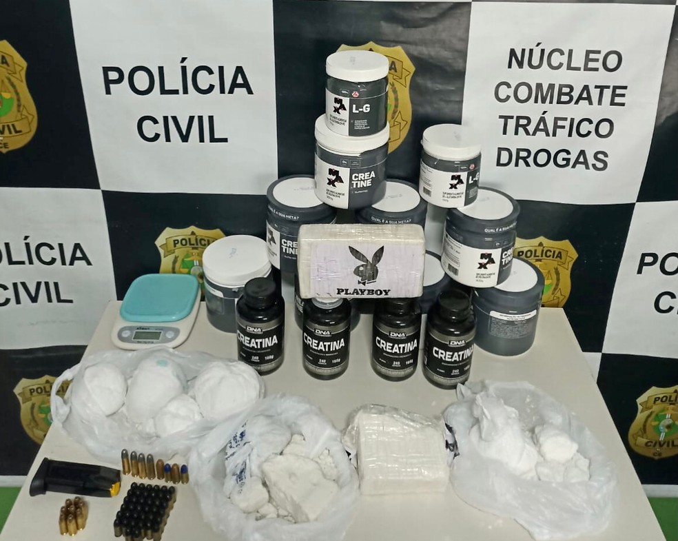 Cocaina armazenada em potes de suplemento, balança de precisão, munição e dinheiro foram apreendidos — Foto: Polícia Civil