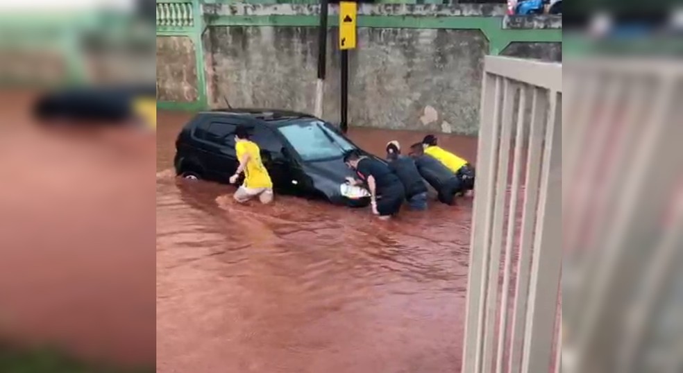 Moradores empurram carro submerso em enxurrada no interior de São Paulo.  — Foto: Redes sociais