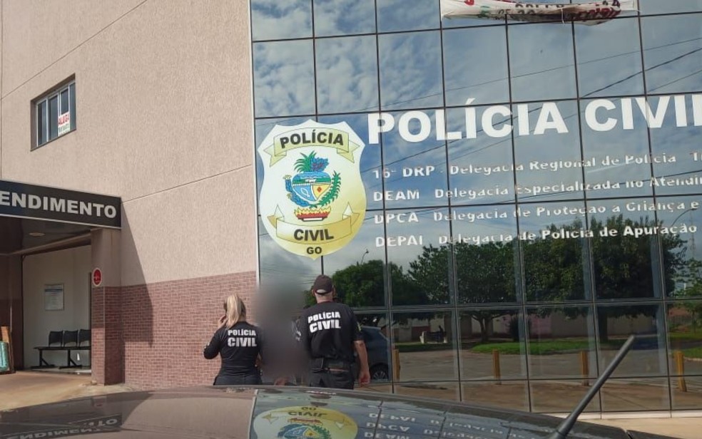 Momento em que a mãe das crianças foi levada presa à delegacia de Trindade, Goiás — Foto: Polícia Civil/Divulgação 