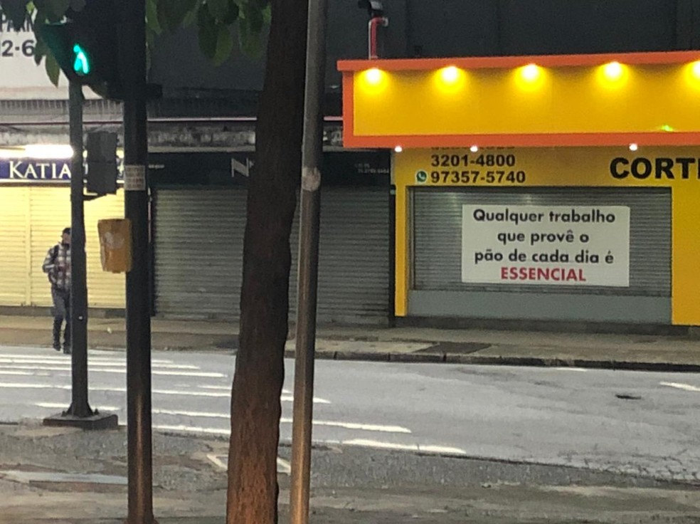 Loja de Belo Horizonte coloca cartaz criticando o conceito de "serviços essenciais", que nortearam o fechamento do comércio durante vários momentos da pandemia na cidade. — Foto: Cristina Moreno de Castro / G1