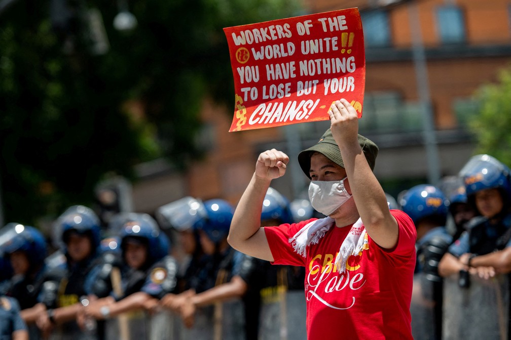 Ativista filipino segura cartaz durante protesto perto da embaixada dos EUA, em Manila, Filipinas, em 1º de maio de 2023 — Foto: Lisa Marie David/Reuters