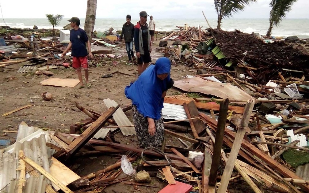 Moradores inspecionam danos em casas na praia de Carita — Foto: AFP Photo