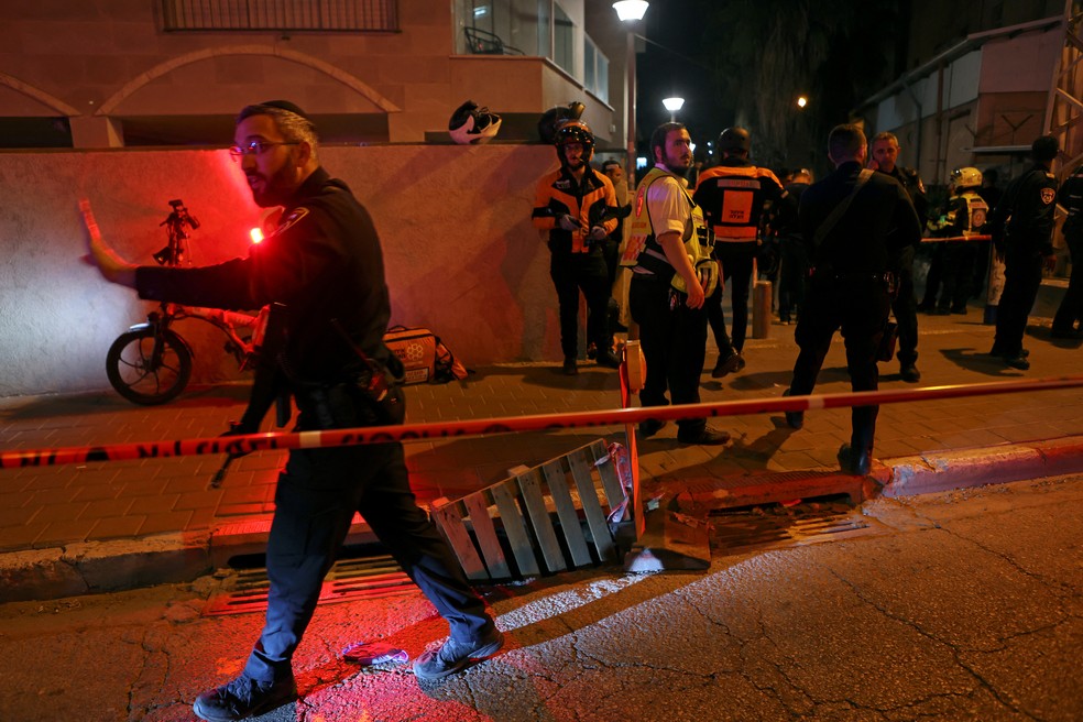 Equipes de segurança e médicos israelenses protegem a cena de um ataque no qual pessoas foram mortas por um atirador em uma rua principal de Bnei Brak, perto de Tel Aviv — Foto: Nir Elias/Reuters