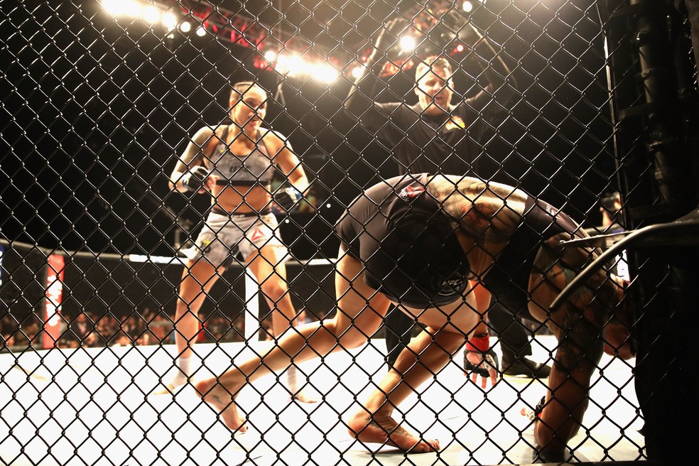 Amanda Nunes observa Cris Cyborg cair nocauteada no UFC 232 — Foto: Getty Images