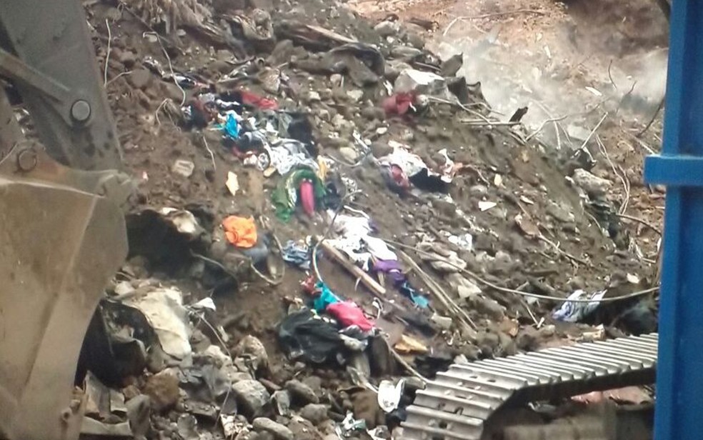 Roupas de moradores são encontradas em meio a destroços enquanto bombeiros avançam nas buscas (Foto: GloboNews/reprodução)