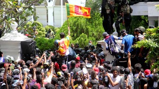 Manifestantes protestam em frente ao escritorio do primeiro-ministro do Sri Lanka, Ranil Wickremesinghe, na capital Colombo, nomeado depois que o presidente Gotabaya Rajapaksa fugiu do país pressionado pelo levante popular, deixando milhões de rúpias para trás — Foto: AFP