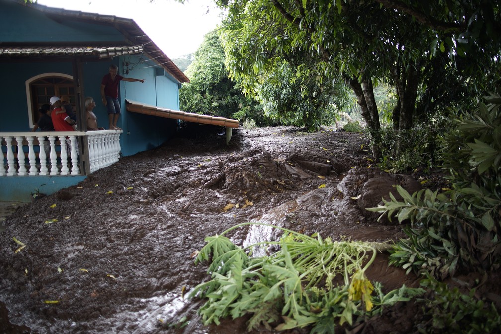 Homem aponta para a lama que invadiu a casa da famÃ­lia em Brumadinho apÃ³s rompimento da barragem da Vale. â Foto: Leo Correa/AP