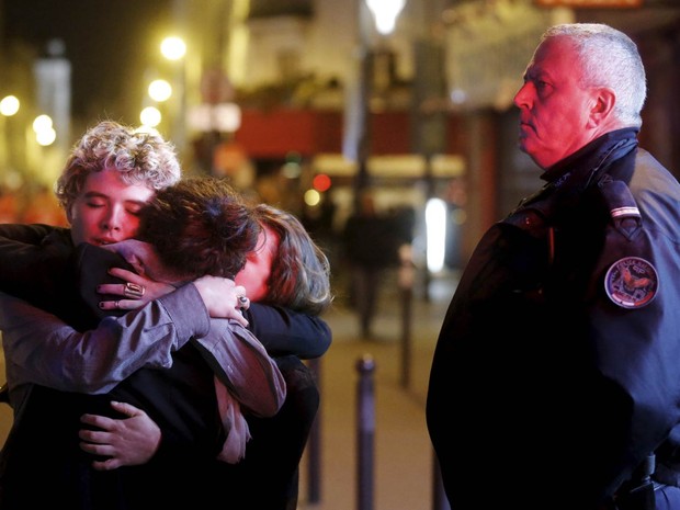 Trio se abraça perto da casa de shows Bataclan após ataque terrorista em Paris (Foto: Christian Hartmann/Reuters)