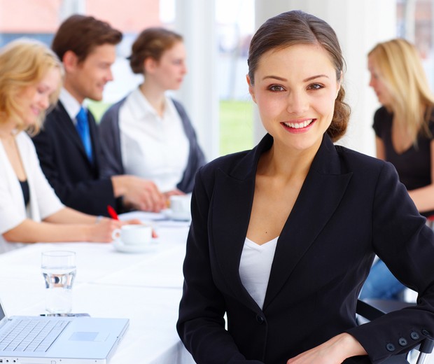 Mulher feliz no trabalho (Foto: Shutterstock)