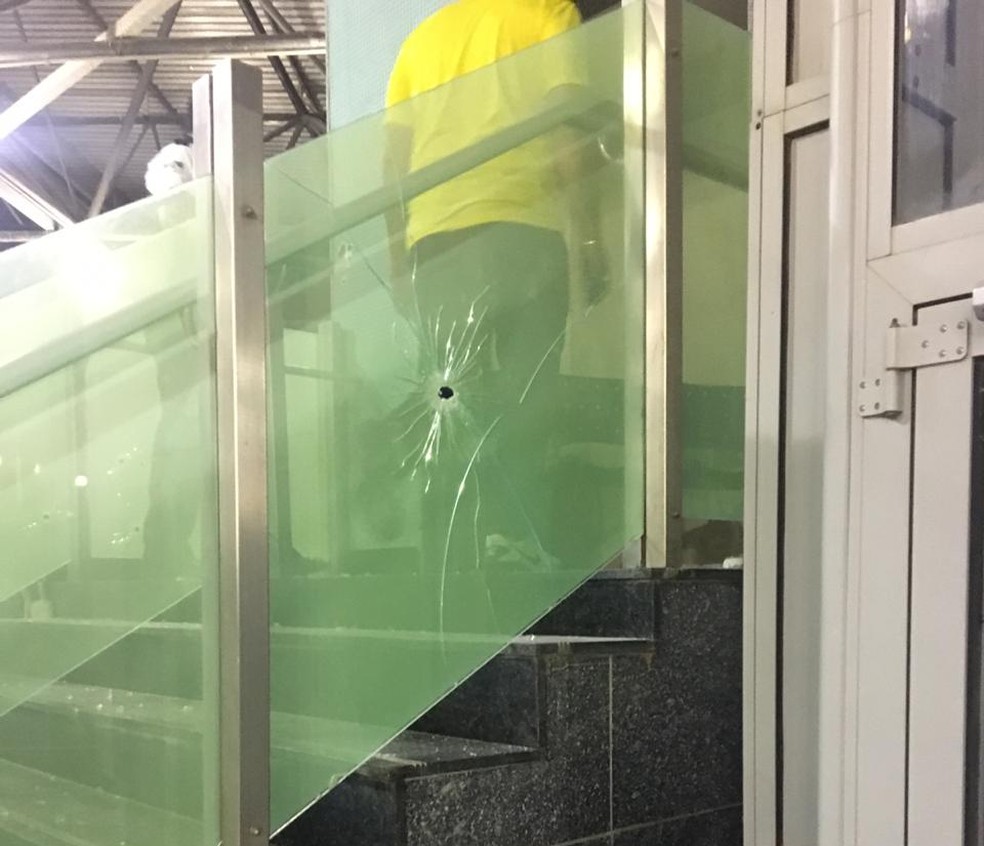 Tiros atingiram a estrutura de vidro da escada. — Foto: Redes sociais.