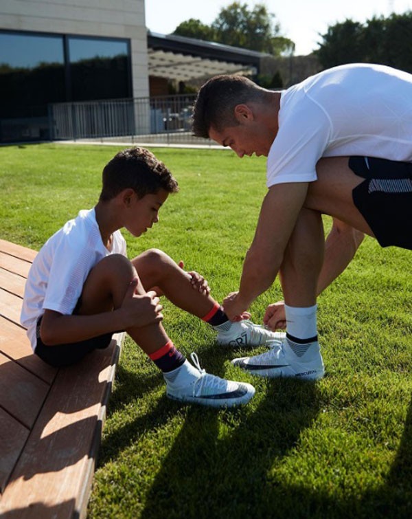 Cristiano Ronaldo amarra as chuteiras do filho mais velho, Jr. (Foto: Reprodução/Instagram)