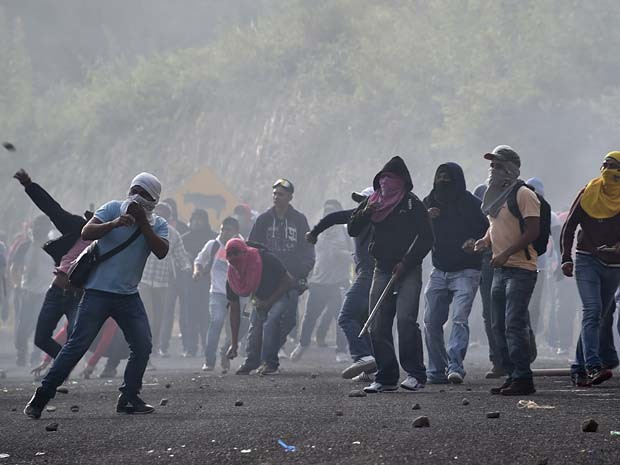 Colegas de estudantes desaparecidos no México enfrentam a polícia nesta terça-feira (22) (Foto: AFP PHOTO / YURI CORTEZ)