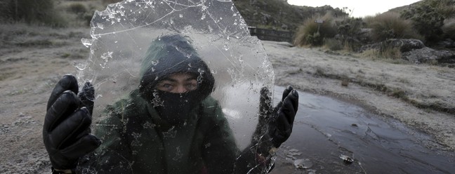 Homem segura placa de gelo no Pico das Agulhas Negras — Foto: Domingos Peixoto / Agência O Globo