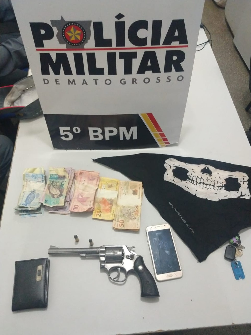 Dinheiro, arma e acessórios usados pelos assaltantes — Foto: Polícia Militar de Mato Grosso/Assessoria