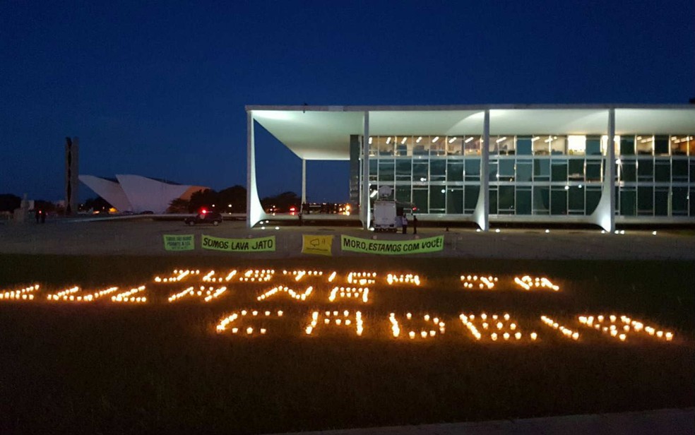 Manifestação contrária ao ex-presidente Lula escreve mensagem com velas em frente ao STF, em Brasília (Foto: Letícia Carvalho/G1)