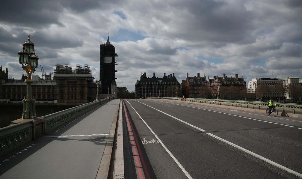 LONDRES - Um ciclista atravessa a ponte de Westminster, em Londres. O ponto turístico está deserto por conta das medidas de contenção do novo coronavírus nesta sexta (3) — Foto: Hannah McKay/Reuters