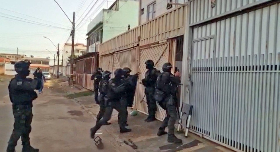 Agentes cumprem mandado na Operação Mercador de Ilusões — Foto: Reprodução/TV Globo