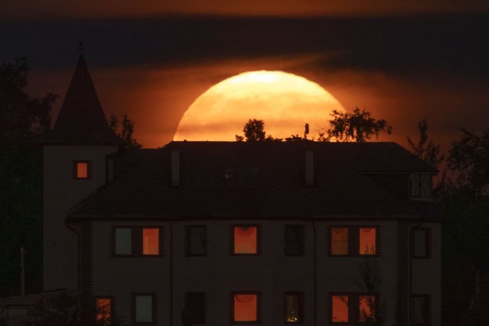 Superlua dos Cervos nasce sobre uma casa particular na vila de Putilovo, 70 quilômetros a leste de São Petersburgo, Rússia — Foto: AP