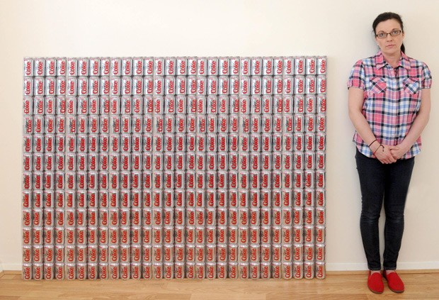 Jakki Ballan ao lado da quantidade de latas que consome, em média, ao longo de uma semana (Foto: Mercury Press)