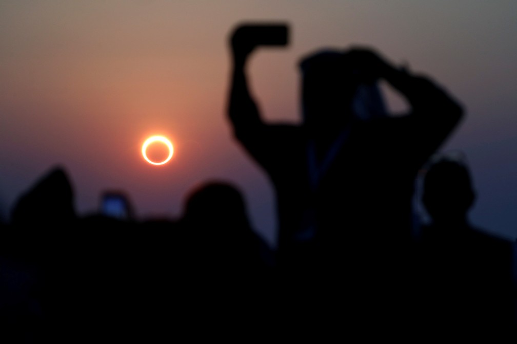 Pessoas tiram fotos com seus smartphones enquanto monitoram o eclipse solar anular na Arbia Saudita  Foto: REUTERS/Hamad I Mohammed