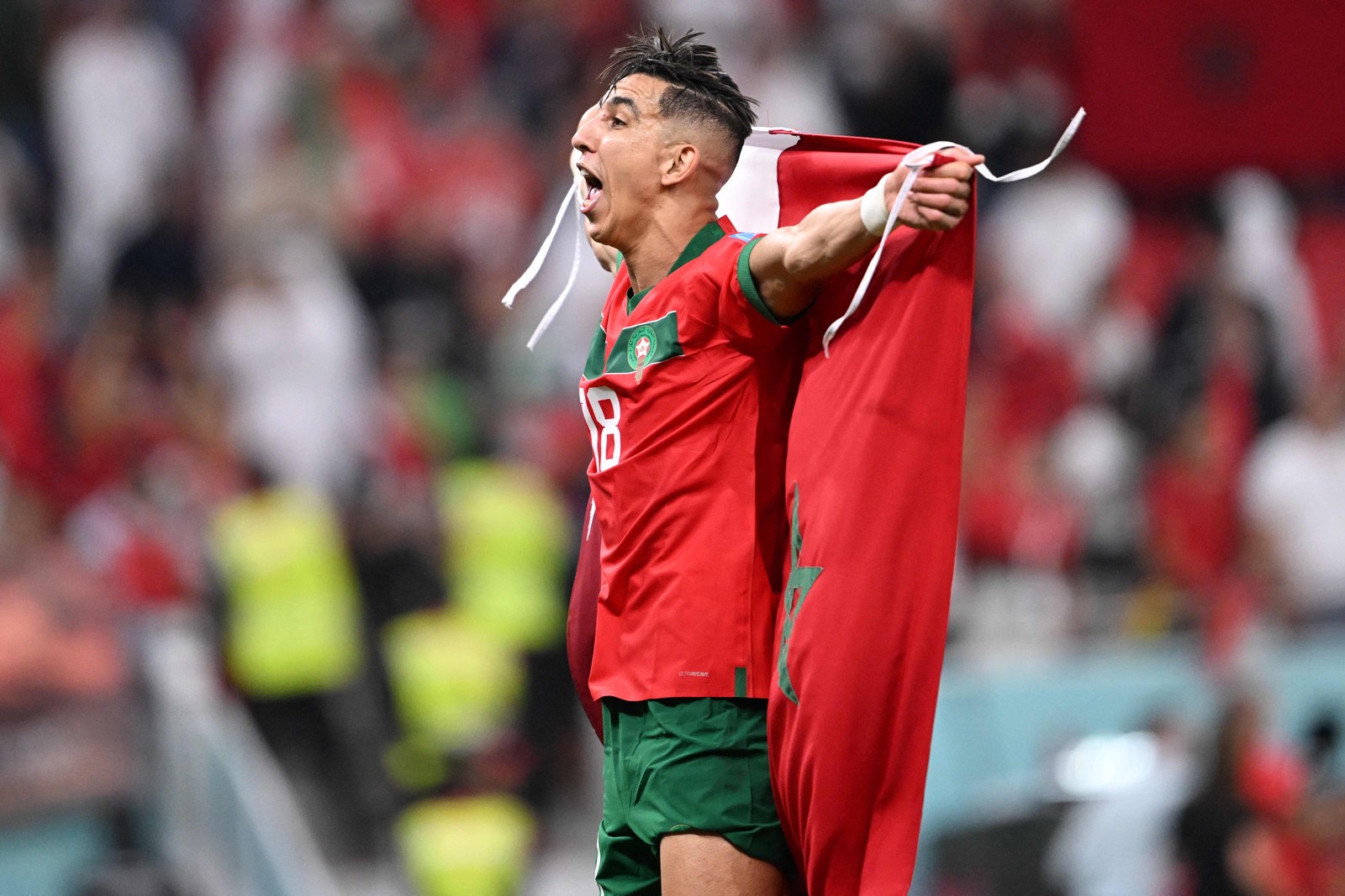 Jawad El Yamiq comemora classificação carregando bandeira de Marrocos e do Catar — Foto: KIRILL KUDRYAVTSEV/AFP