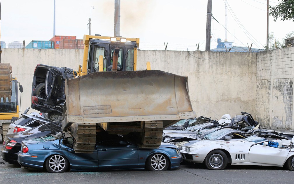 Escavadeira destrói carros de luxo contrabandeados apreendidos em Manila, nas Filipinas, na terça-feira (6) (Foto: Reuters/Romeo Ranoco)