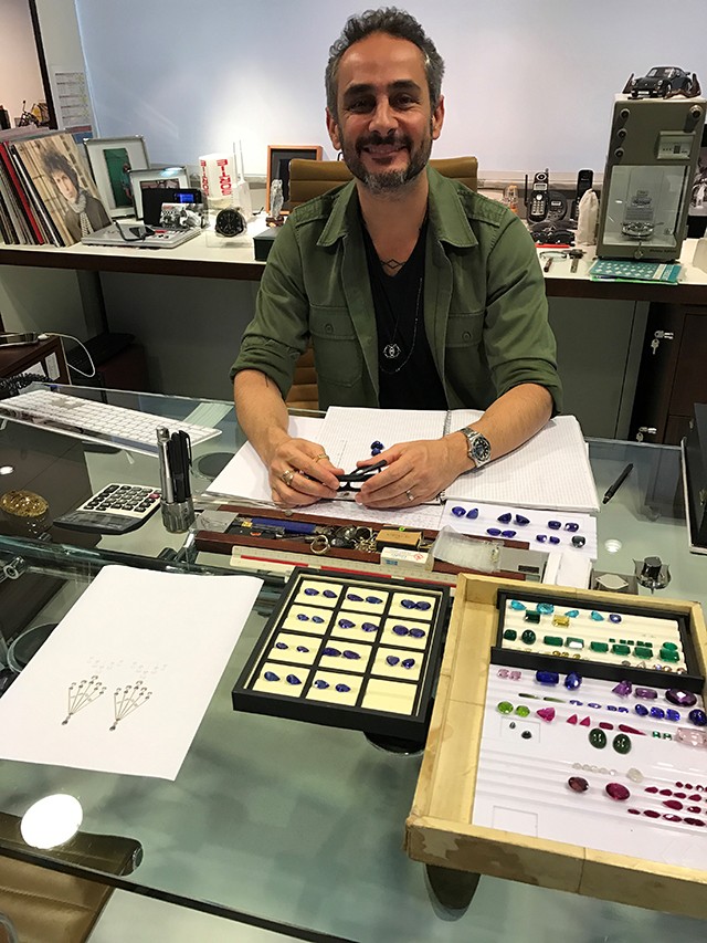 Ara at his desk in his São Paolo studio, surrounded by a collection of stones (Foto: @SuzyMenkesVogue)