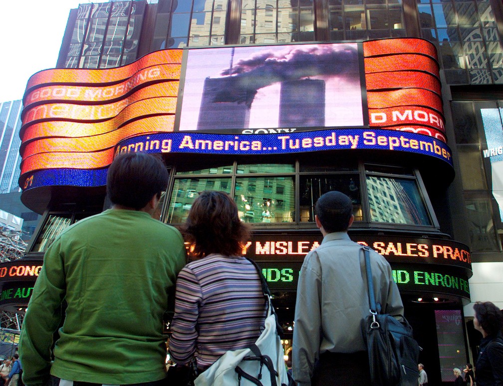 Pessoas assistem telão na Times Square, no Centro de Manhattan, mostrando o World Trade Center em chamas na parte sul da ilha antes de a segunda torre ser atingida — Foto: Shannon Stapleton/Reuters/Arquivo