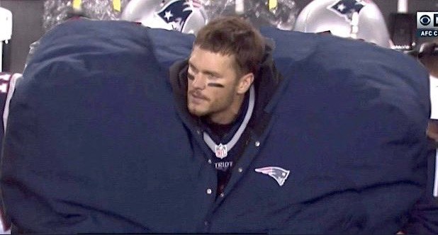 O jogador de futebol americano Tom Brady protegido por um agasalho imenso  (Foto: Reprodução)
