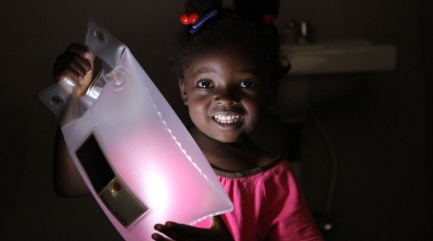 Criança do Haiti com luminária da LuminAid (Foto: Divulgação)