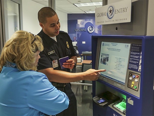 Funcionário da imigração americana explica uso da máquina do sistema Global Entry a usuária (Foto: Divulgação/US Customs and Border Protection/ Josh Denmark)