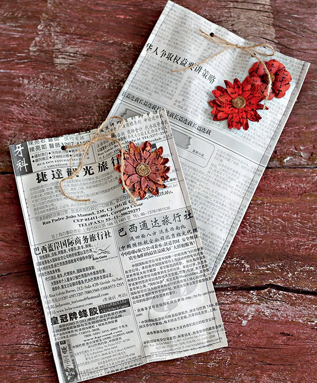 Jornal japonês costurado como envelope, com flor de scrapbook (Foto: Elisa Correa/Editora Globo)
