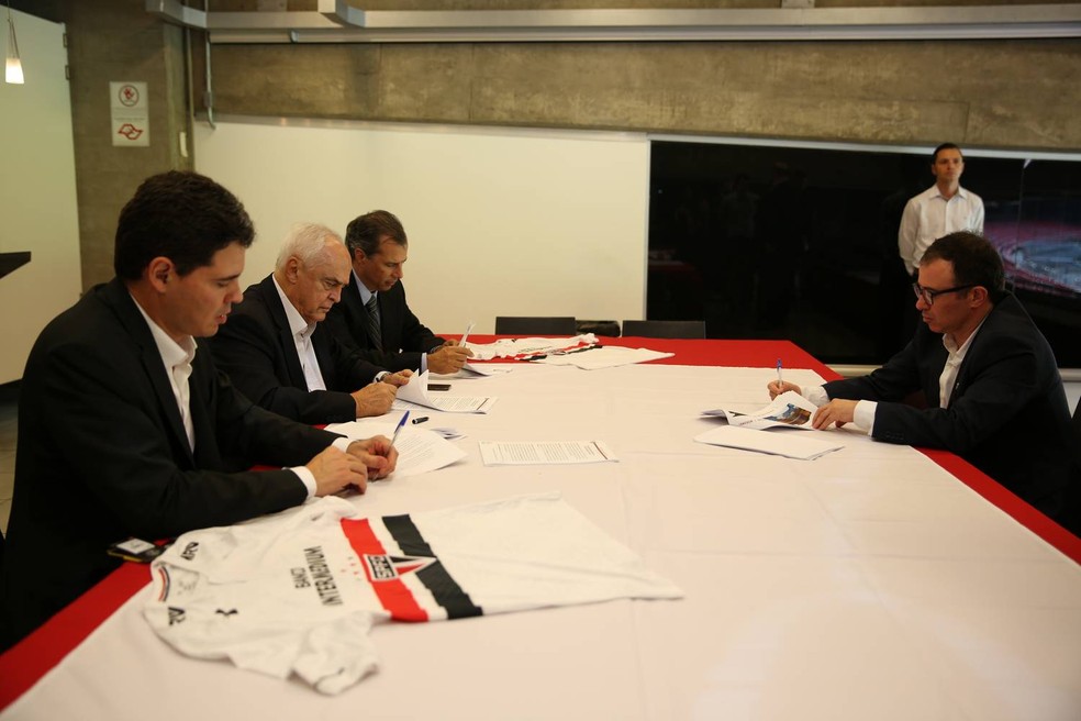 Marcio Aith (direita) e presidente Leco (ao centro na esquerda) assinam contrato com patrocínio máster (Foto: Igor Amorim / saopaulofc.net)