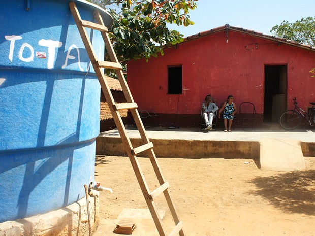 Seu Raimundo e dona Maria têm uma cisterna e uma caixa d’água na porta de casa, mas reclamam que o abastecimento não é regular (Foto: Anderson Barbosa/G1)