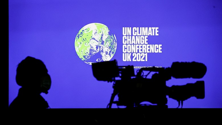 Cinegrafista em frente ao logo da COP26 durante entrevista coletiva em Glasgow (Foto: REUTERS/Phil Noble)