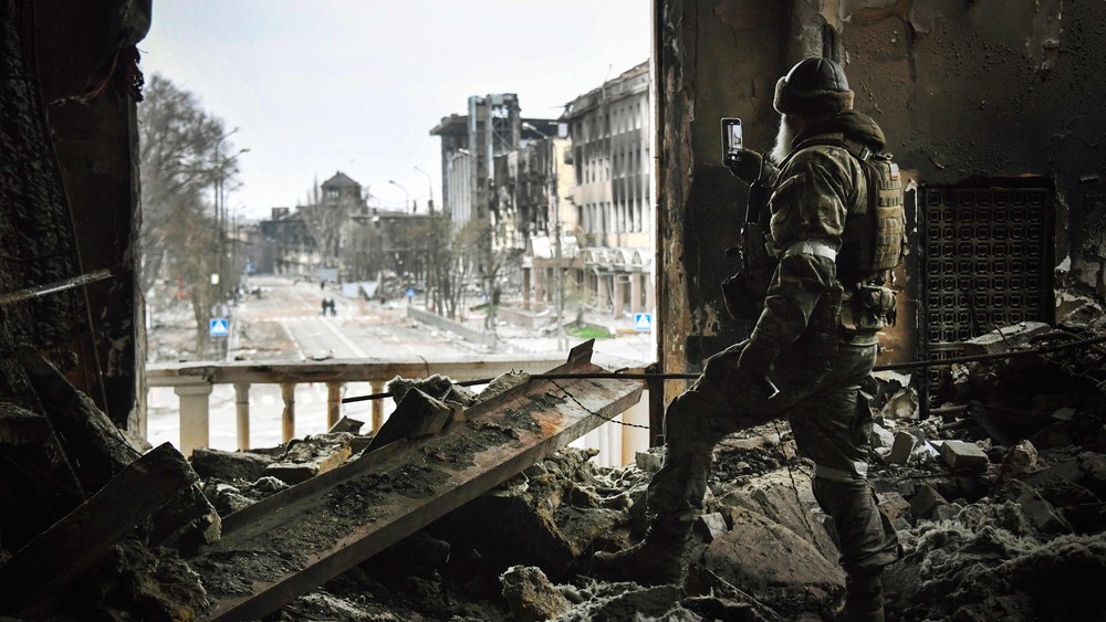 Soldado russo patrulha, em 12 de abril, o teatro dramático de Mariupol, bombardeado em 16 de março, enquanto as tropas russas intensificam uma campanha para tomar a estratégica cidade portuária.