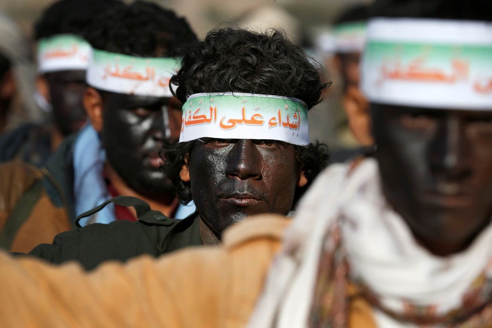 Novos recrutas Houthi participam de ensaio para um desfile militar antes de seguirem para a linha de frente no combate contra forças do governo iemenita em Sana. As faixas nas cabeças levam a mensagem: 'Somos duros contra infiéis' (Foto: Khaled Abdullah/Reuters)