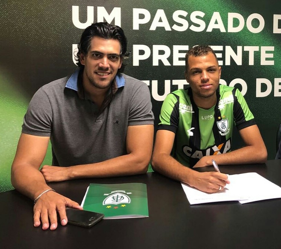 Goldeson assinou primeiro contrato como profissional ao lado de Paulo Bracks, diretor da base do América-MG (Foto: Mourão Panda / América-MG)