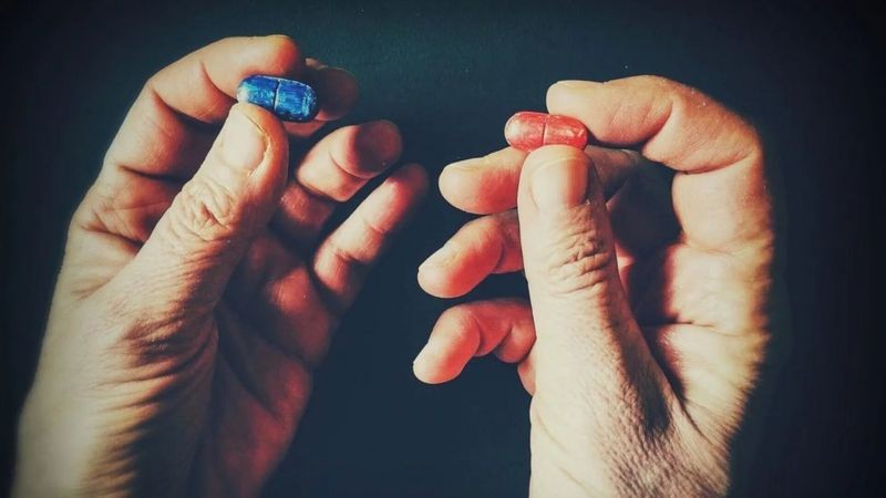 Se você fosse o personagem Neo do filme Matrix, você tomaria a pílula azul ou a vermelha? (Foto: Getty Images via BBC News)
