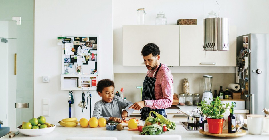 A father and son at home in the kitchen helping each other prepare some lunch. (Foto: Getty Images)