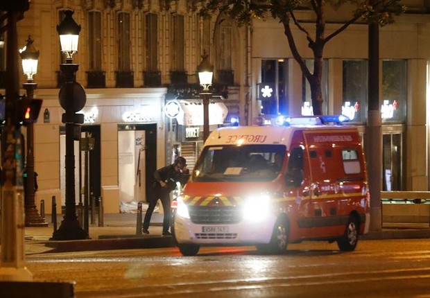 Policiais fecham a área na avenida Champs Élysées, onde um tiroteio deixou dois mortos em Paris (Foto: Ian Langsdon/EFE)