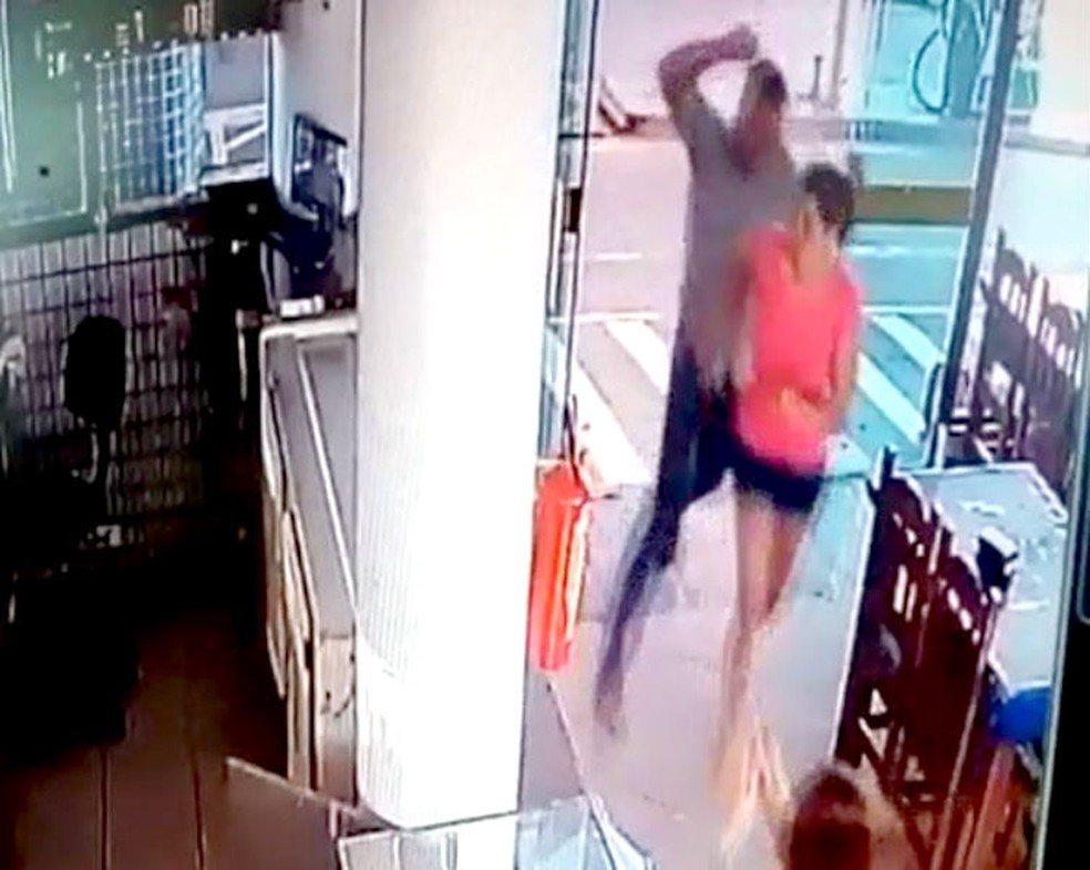 Após escapar dos disparos, irmão do genro da mulher a acerta com um soco na cabeça — Foto: Câmeras de segurança/Reprodução