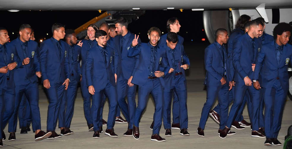 Neymar sorri e faz gesto de vitória na chegada à Rússia: craque do PSG ainda estava em recuperação da melhor forma