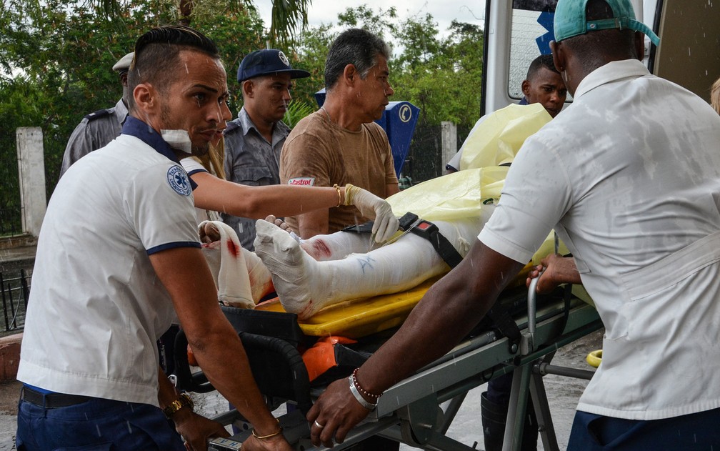 Sobrevivente do acidente com um avião em Cuba é socorrida por paramédicos na sexta-feira (18) (Foto: Marcelino Vazquez Hernandez/ACN/Handout via Reuters)
