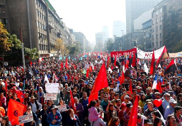 Manifestantes em passeata em Santigo, Chile, durante comemorações do 1º de maio convocada pelos sindicatos (Foto: Esteban Garay/EFE)