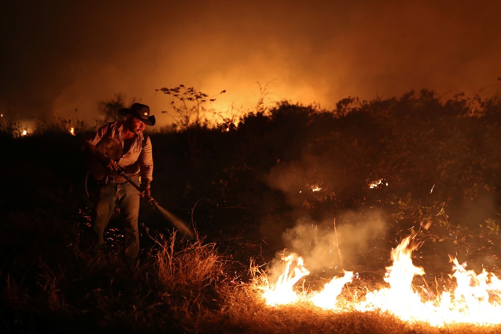 Sebastião Baldi Silva Junior, de 40 anos, tenta apagar um incêndio em uma fazenda no Pantanal, a maior área úmida do mundo, em Poconé (MT) — Foto: Amanda Perobelli/Reuters