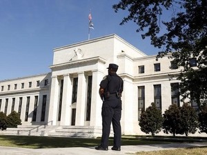 Policial observa o prédio do Federal Reserve, em Washington (Foto: Kevin Lamarque/Reuters)